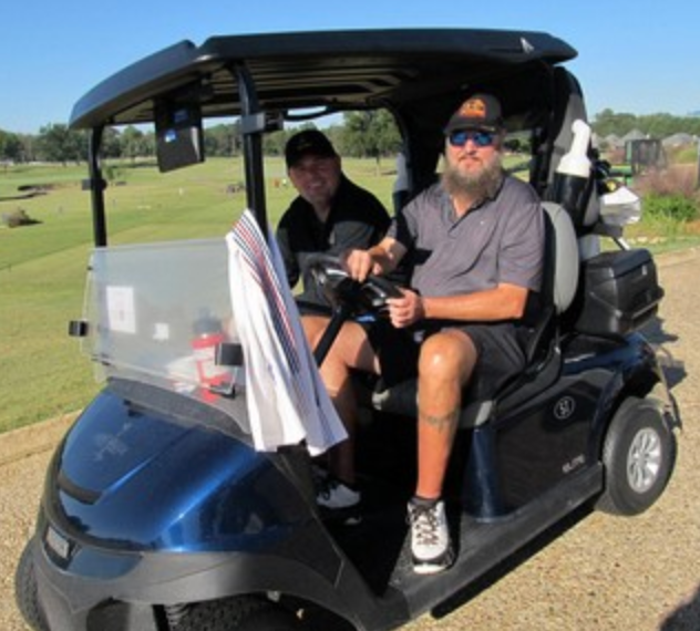 Two golfers riding in a golf cart on the course