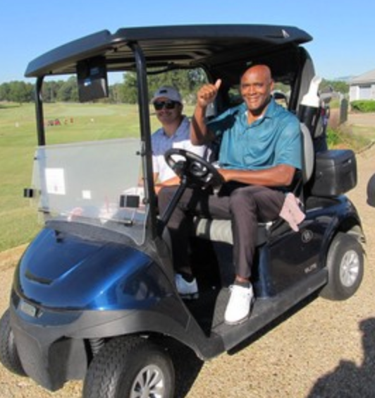 Golfer giving a thumbs up from a golf cart