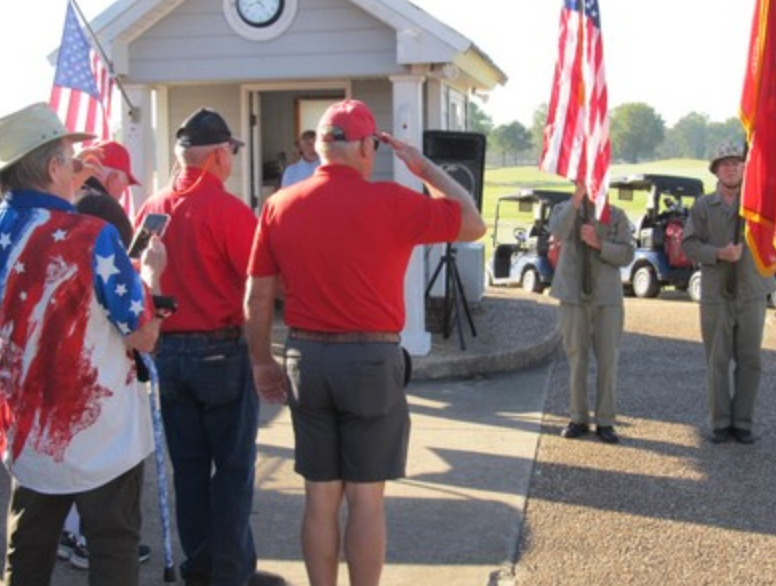 Members saluting during opening ceremony at golf tournament