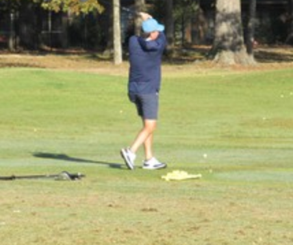 Golfer following through on a swing at Bent Brook