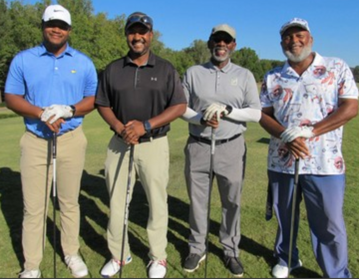 Foursome posing on the course in polo shirts