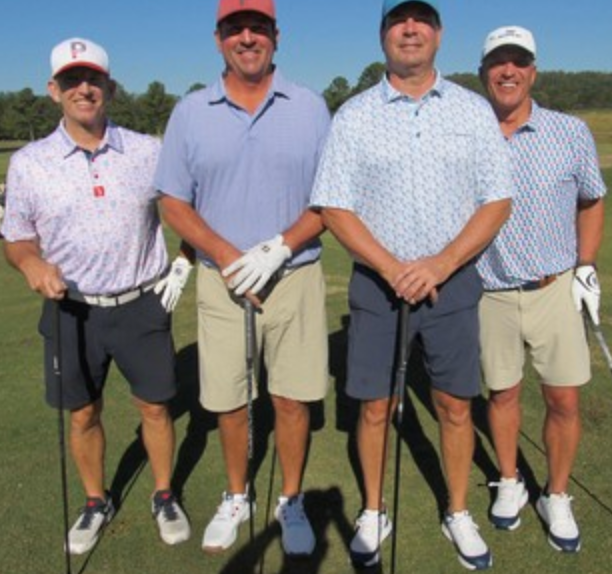 Foursome posing on the course in patterned shirts