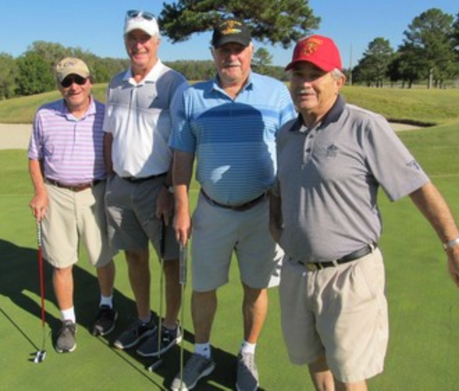 Foursome posing together on the putting green
