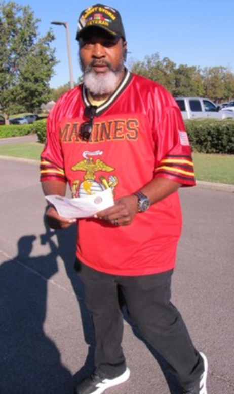 Marine in red Marines jersey holding tournament papers