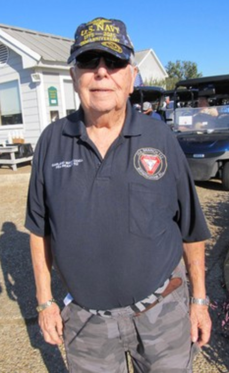 Navy veteran in U.S. Navy cap and Marine Corps shirt at the golf tournament
