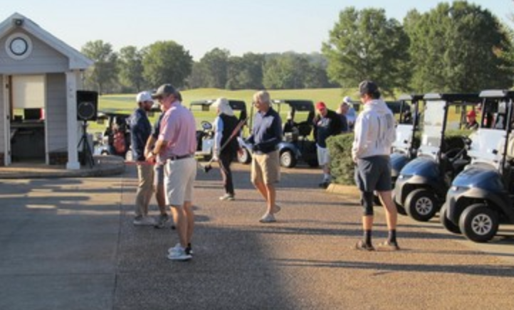 Golfers gathering in the staging area with carts before tee off