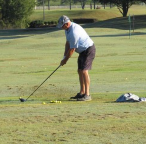 Golfer teeing off at the driving range