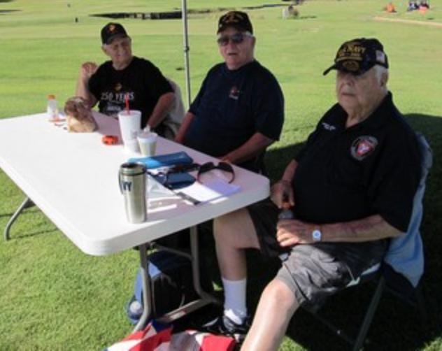 Three veterans seated at a table at the golf tournament