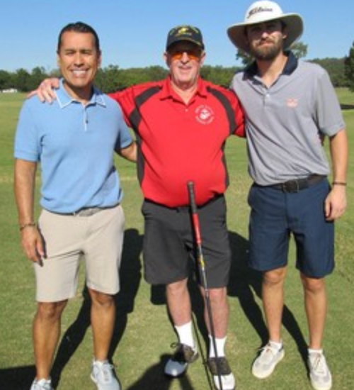 Three golfers posing together on the fairway