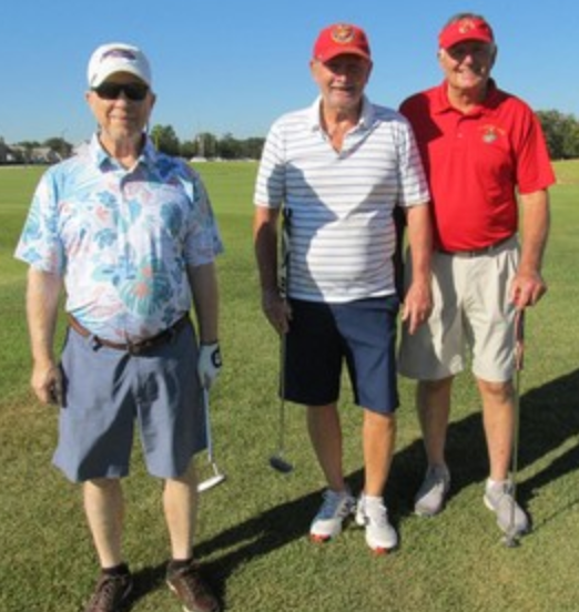Three golfers posing, two in Marines red caps and shirts