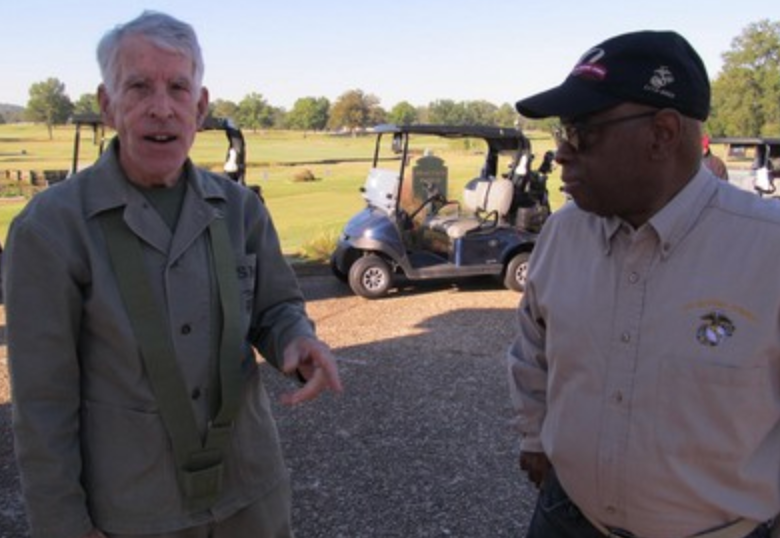 Two veterans in conversation near golf carts