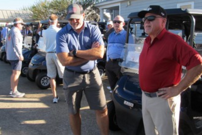 Two golfers standing by golf carts before the round