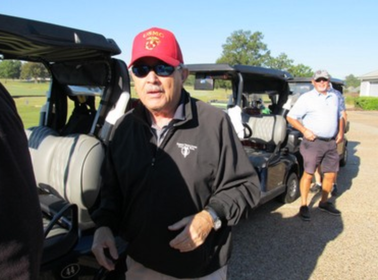 Marine in USMC red cap standing by golf carts
