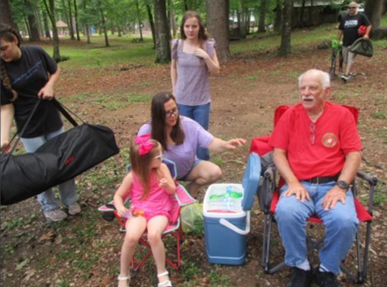 Family and member seated outdoors