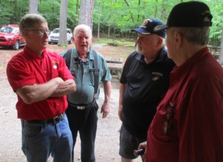 Four members in conversation outdoors