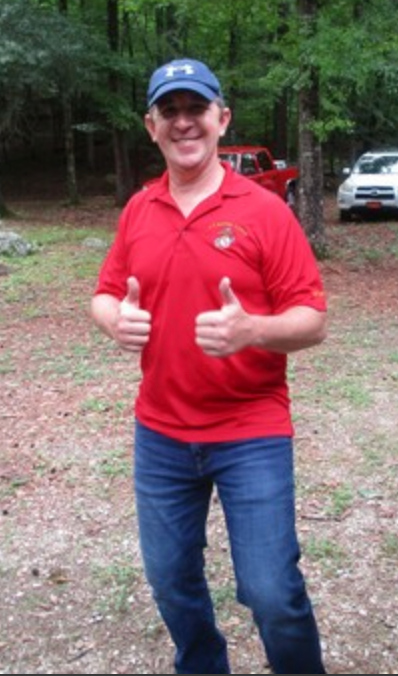 Member giving thumbs up in red Marine Corps shirt