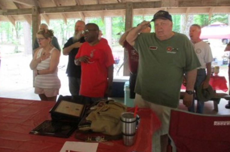 Members saluting at pavilion meeting