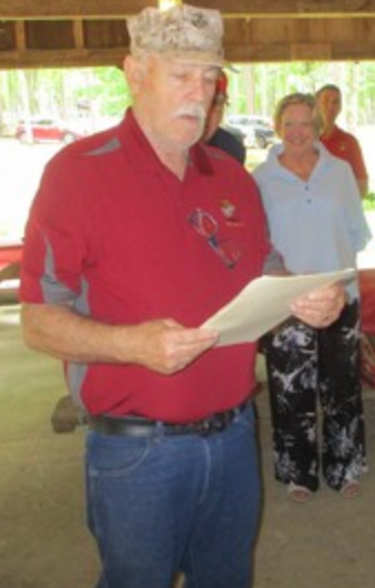 Member reading from paper at pavilion