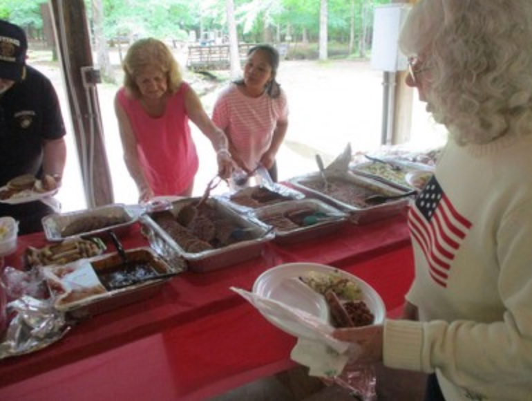 Members serving food at buffet table