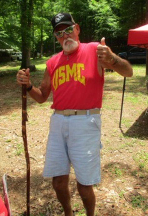 Member in USMC shirt giving thumbs up outdoors