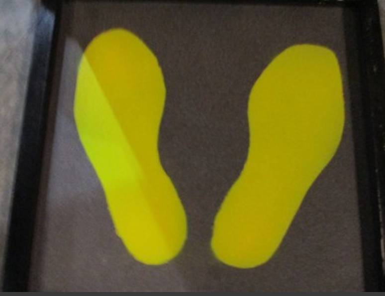 Yellow footprints on dark background