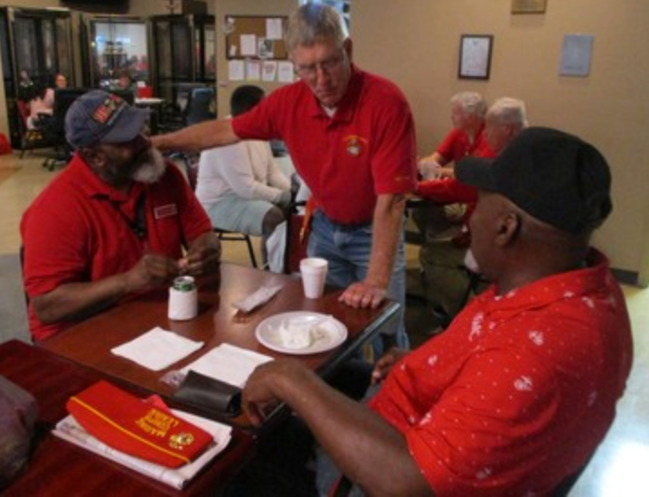 Three members in red shirts conversing at table