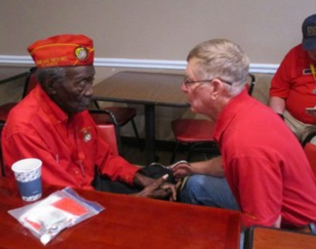 Two members in red shirts in conversation