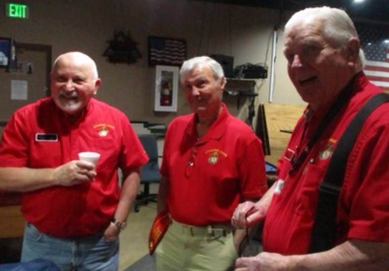 Three members in red shirts laughing together