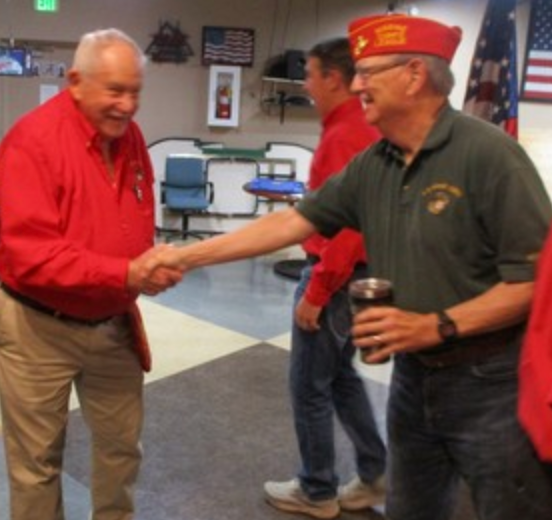 Two members shaking hands at indoor event