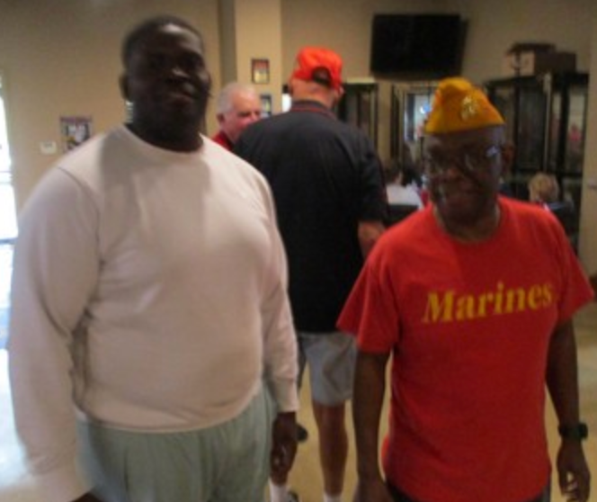 Two members in Marines shirt at indoor gathering