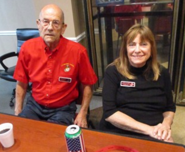 Two members seated at table at indoor meeting