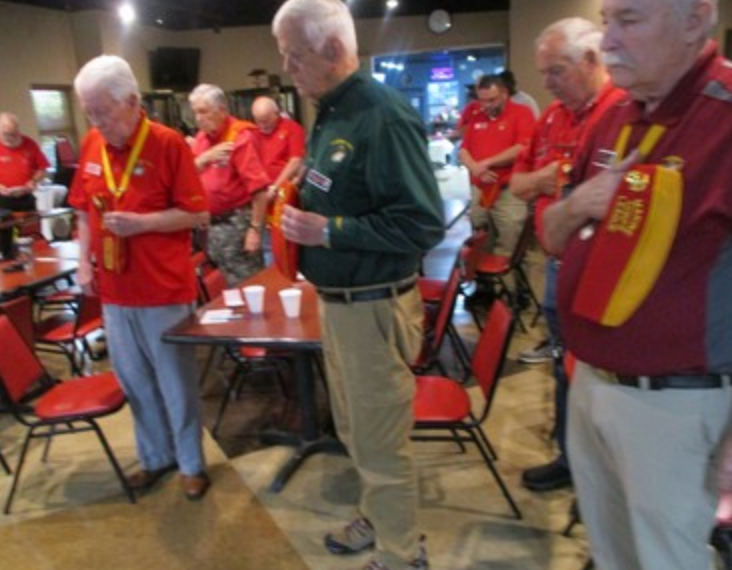 Members bowing heads in prayer at meeting