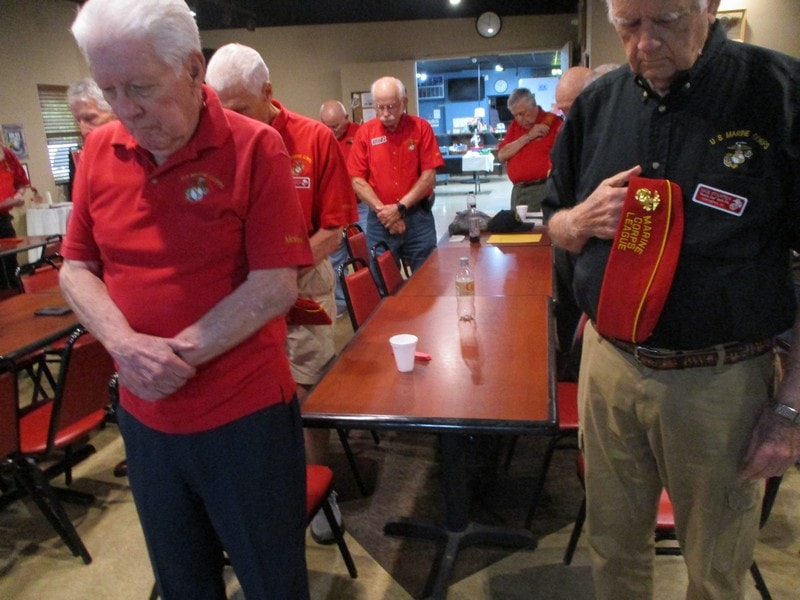 Senior veterans gathering in red uniforms indoors