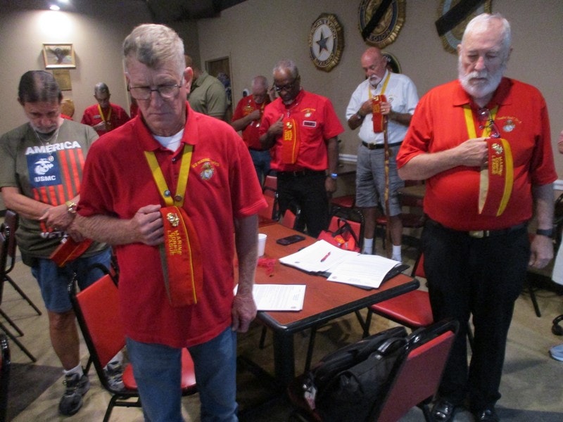 Members in red uniforms at indoor meeting