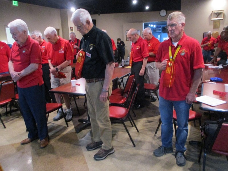 Senior volunteers in red shirts gathering indoors