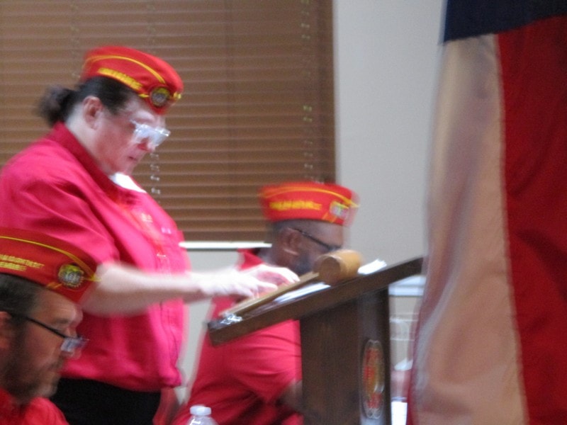 Members in red uniforms at podium ceremony