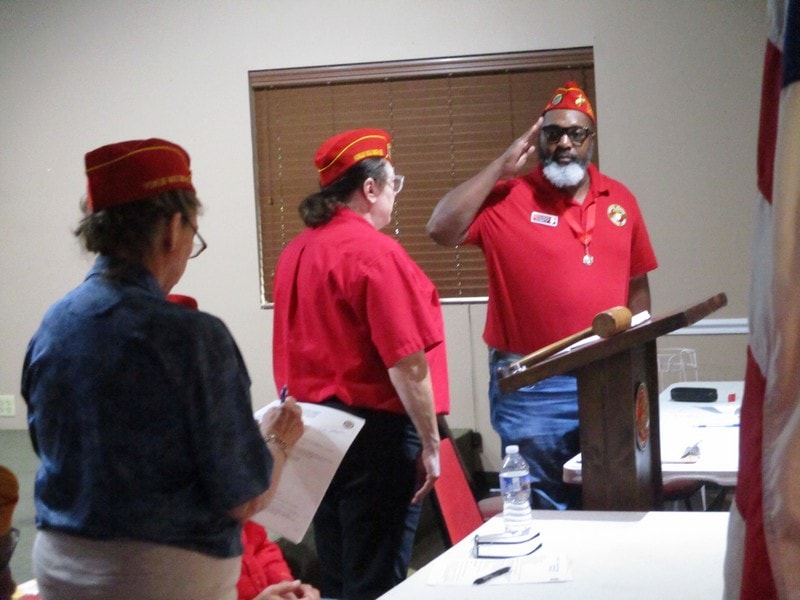 Members wearing red hats at meeting