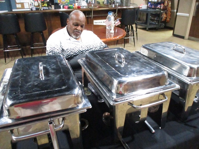 Member inspecting catering chafing dishes