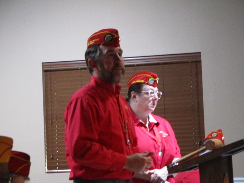 Members in red uniforms performing ceremony