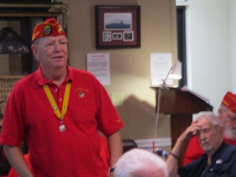Veteran in red uniform speaking indoors