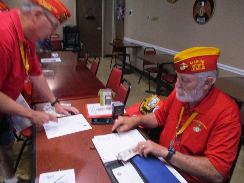 Marine League member signing documents at table