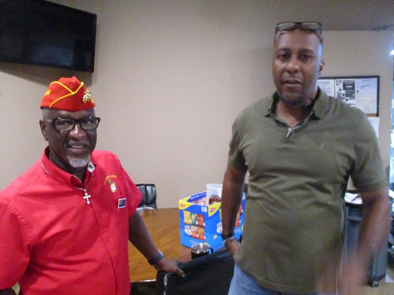 Two members standing indoors with toy donation
