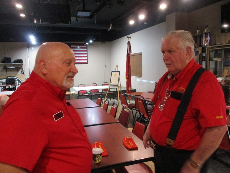 Two members in red shirts talking indoors