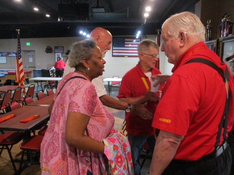 Marines greeting community members indoors