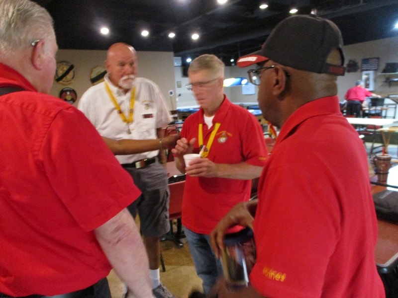 Group of members in red shirts conversing indoors