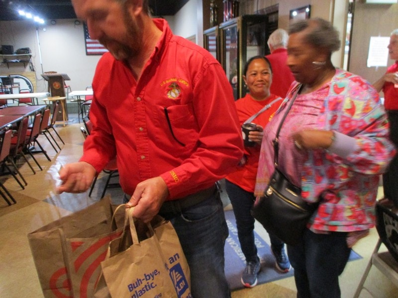 Member distributing food bags at community event