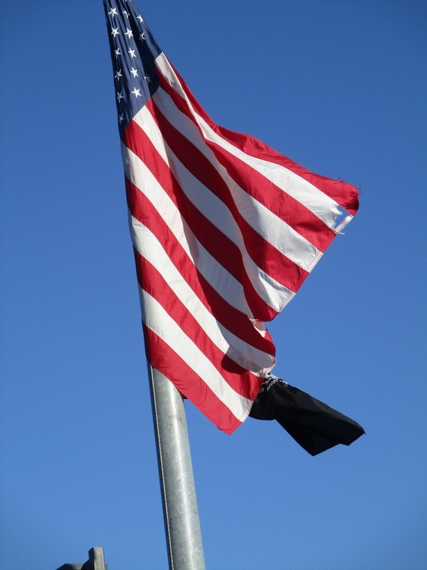 American flag waving against clear blue sky