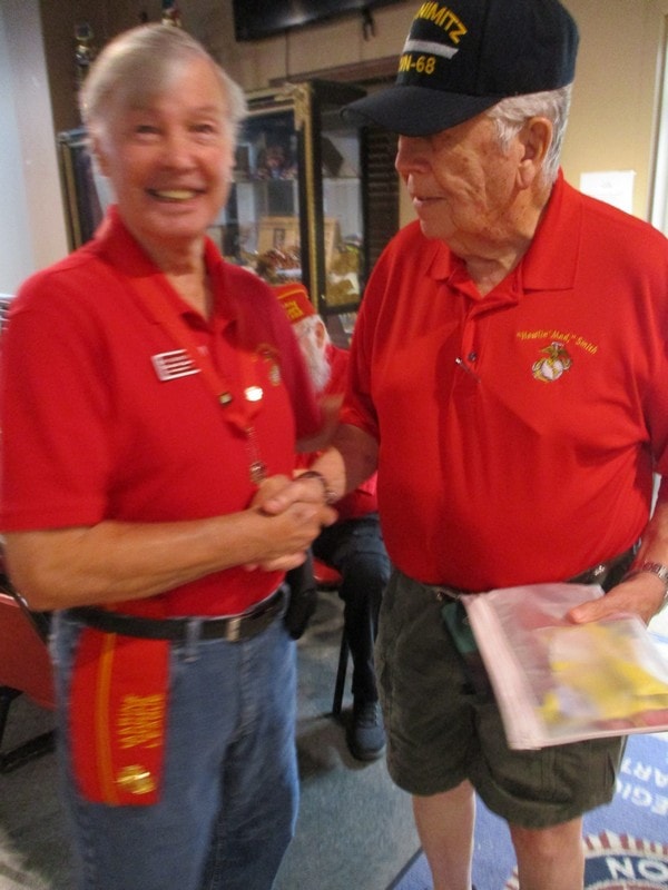 Two veterans shaking hands in red shirts