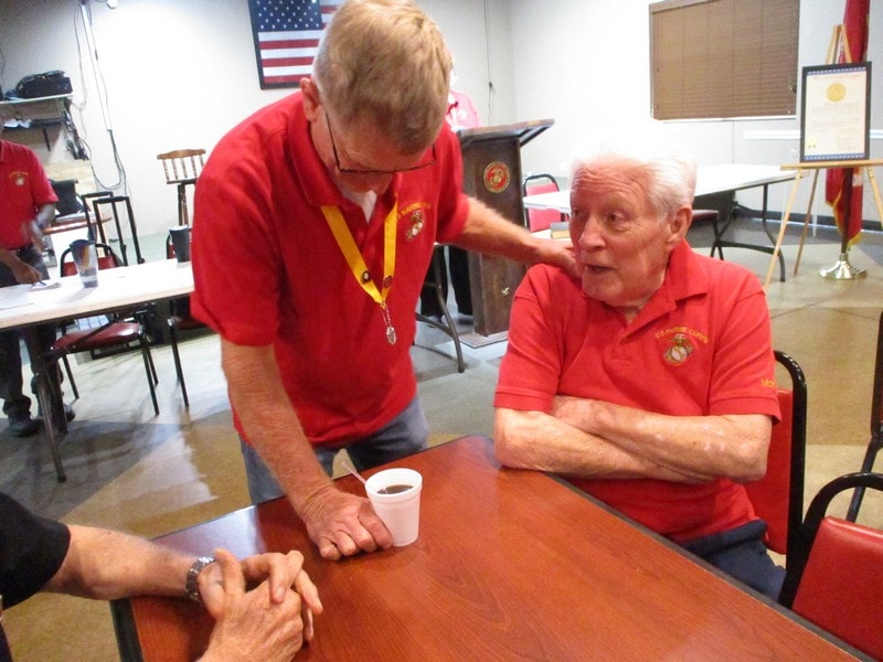 Veterans in red shirts conversing indoors