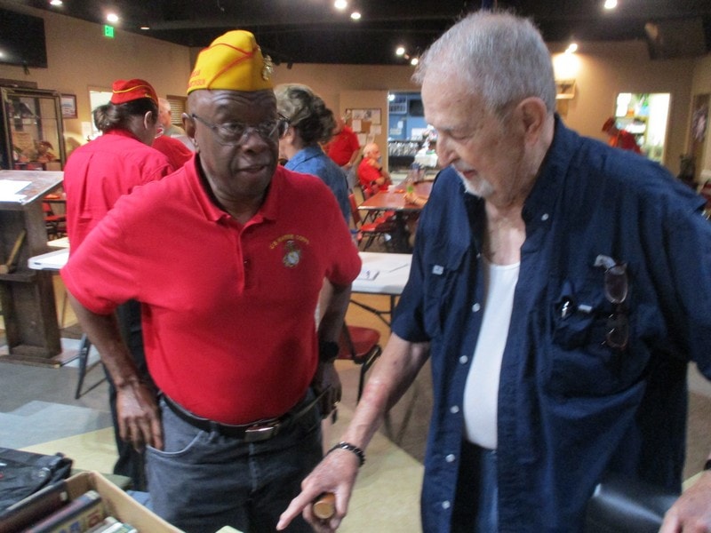 Veterans in military caps at indoor event